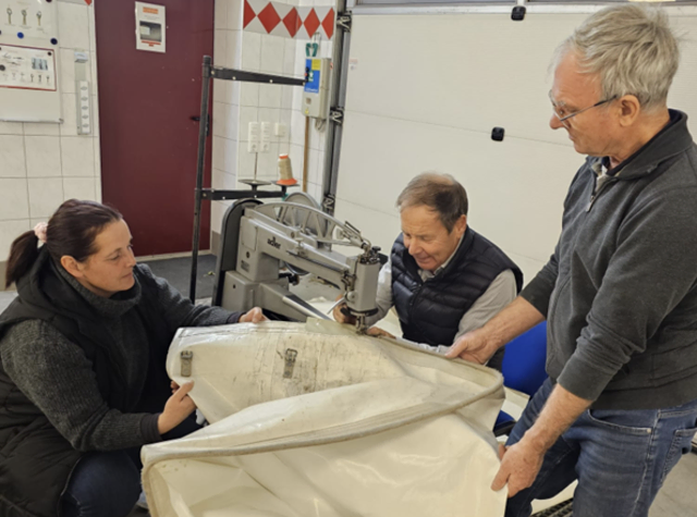 Marion Böhm und Ex-Bürgermeister Josef Langthaler (r.) unterstützen Josef Atteneder beim Nähen der Zeltplane. | Foto: FF Langfirling