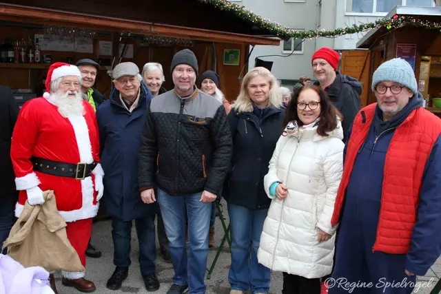 Pressbaums stattlicher Weihnachtsmann Günter Brazda, StR und Obmann StV des Verschönerungsvereins Rudolf Mlinar, StR Jutta Polzer, Bürgermeister Josef Rothensteiner, GR Sabine Puschnig-Berghofer, GR Michael Sigmund, Vizebürgermeisterin Ingrid Burtscher und Gregor Puschnig- er sorgte für  Stabilität in den Elektrokabeln der weihnachtlichen Standln.