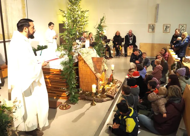 Kurat Felician mit den Kindern vor der Krippe