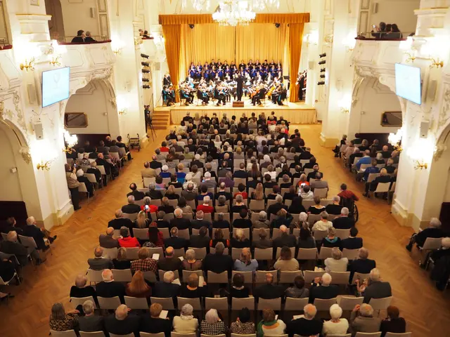 Voll besetzter Sparkassensaal im Zuschauerraum und auf der Bühne.