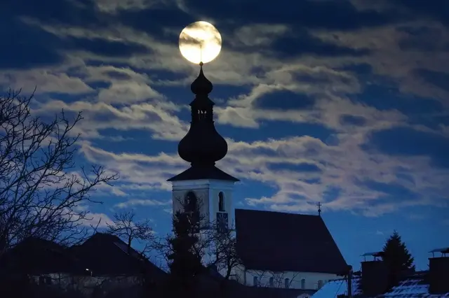 Der Vollmond punktgenau aufgesetzt auf dem Kirchturmkreuz der Kaplaneikirche Kirchberg.
 | Foto: Gerhard Hütmeyer