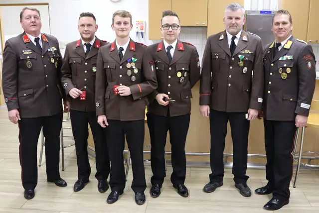 Die Beförderten halten ihre neuen Dienstgrade in der Hand