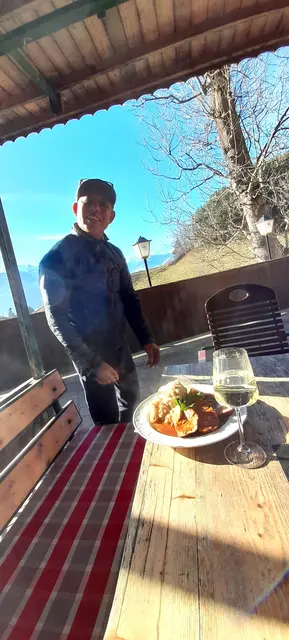 Raju serviert bei schönem Winterwetter im Gastgarten für kältefeste Gäste persönlich Schweinsbraten mit Kraut und Knödel | Foto: Stracke