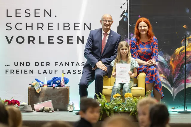 53 Volksschulen nehmen beim landesweiten Geschichtenwettbewerb zum Vorlesetag 2026 teil (im Bild: Landeshauptmann Anton Mattle und Landesrätin Cornelia Hagele mit Vorjahressiegerin Theresa Haider). | Foto: Land Tirol/Die Fotografen