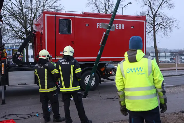Ein angefahrener Lichtmast in Wels-Pernau drohte umzufallen und musste mittels Kran demontiert werden.