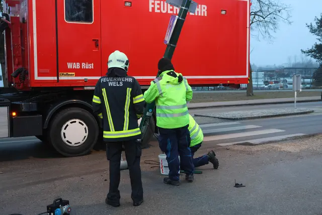 Ein angefahrener Lichtmast in Wels-Pernau drohte umzufallen und musste mittels Kran demontiert werden.