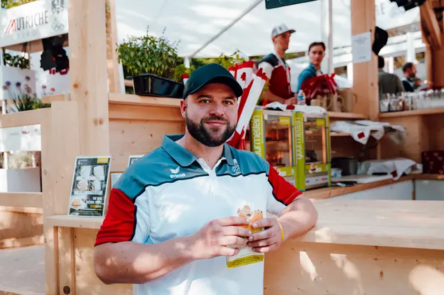Lukas Weißhaidinger mit Leberkäsesemmerl im Austria House in Paris 2024. | Foto: Niklas Stadler