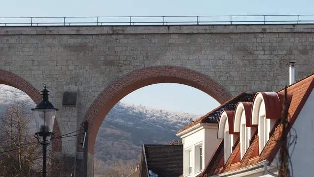 Das "Tor zum Helenental": Blick von der Schlossgasse durch den Aquädukt auf die rauhreifbedeckten Baumwipfel des Lindkogels