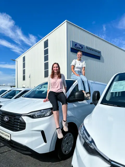 Christina Kargl und Annalena Reiß bei den Ford-Fahrzeugen am Firmengelände.