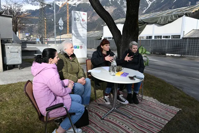 Direkt vor dem Firmensitz der Innsbrucker Immobilien Gesellschaft (IIG) in der Rossaugasse wurde ein runder Tisch auf dem kleinen Wiesenabschnitt aufgebaut. Ziel der Aktion: den Anliegen der IIG-Mieterinnen und Mieter endlich Gehör verschaffen.  | Foto: Königer
