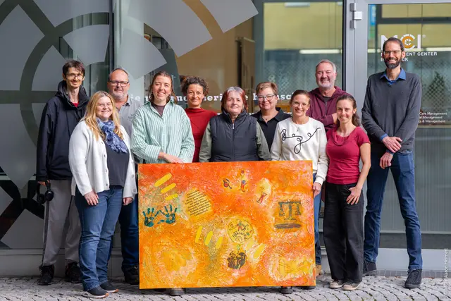 Die Künstlerinnen und Künstler der Gruppe „Kunst Kultur Natur“ präsentieren ihr gemeinsames Kunstwerk am MCI Innsbruck, das Forschung, Teilhabe und Gemeinschaft sichtbar macht. | Foto: Aaron Heimerl/ MCI