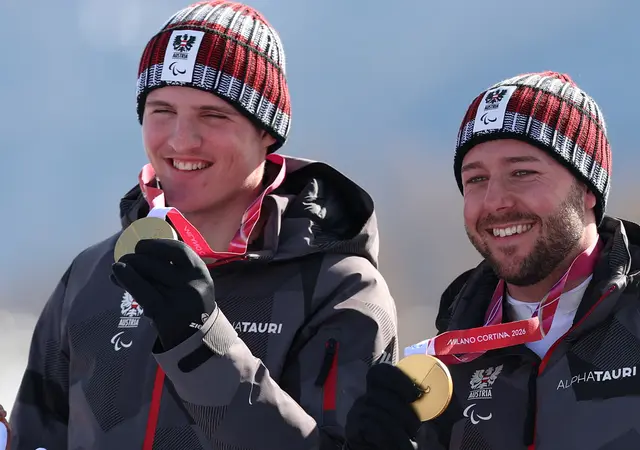Johannes Aigner und sein Guide Nico Haberl feiern die Goldmedaille bei der Siegerehrung der Männer-Abfahrt am 7. März 2026. | Foto: APA-Images / AP / Kentaro Tominaga