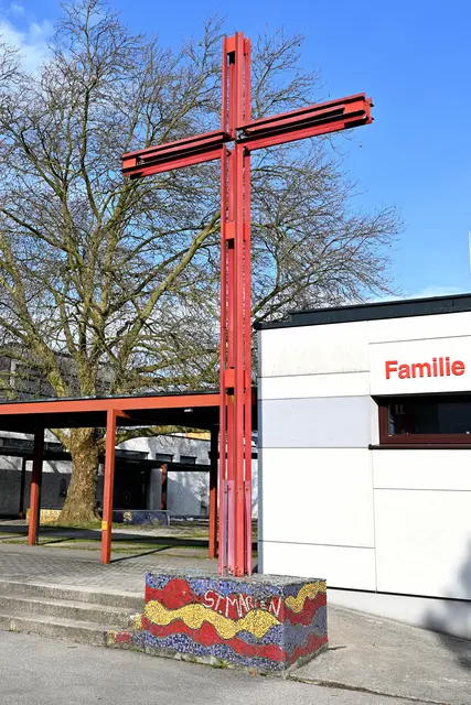 Das ursprünglich schwarze Kreuz bekam 2002 einen roten Anstrich und wurde der 80 Zentimeter hohe Betonsockel mit bunten Mosaiksteinchen von Jungscharkindern verkleidet. | Foto: Hans-Peter Kriener