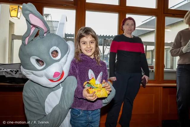 Auch wenn der Osterhase sehr groß war, Laura fürchtete sich nicht. Im Hindergrund gf. GRin Belinda Panzenböck. | Foto: cine-motion.at / R. Ivanek