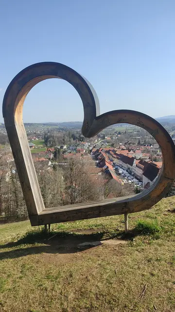 Der Bad Schwanberger Hauptplatz, gefüllt mit Jahrmarktständen, das hölzerne Herz steht etwas unterhalb der Josefikirche am Rosenkranzweg, ein Fußweg, welcher von der Pfarrkirche ausgehend zur Josefikirche führt. | Foto: Günther Koch