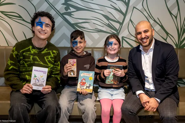Musiker Cosmó (li.) und Hamed Mohseni (Billa-Vertriebsdirektor, re.) mit zwei Schulkindern beim Österreichischen Vorlesetag. | Foto: BILLA AG / Robert Harson