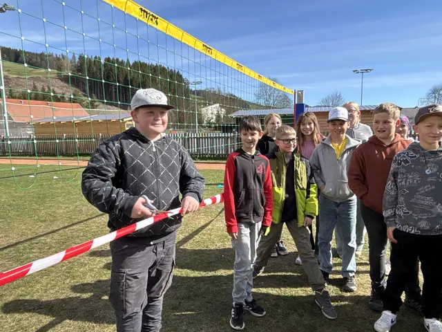 Ein Schüler der 4B-Klasse beim Durchschneiden eines Bandes vor dem neuen Volleyballnetz bei der offiziellen Übergabe.  | Foto: MeinBezirk/Angelina Koidl