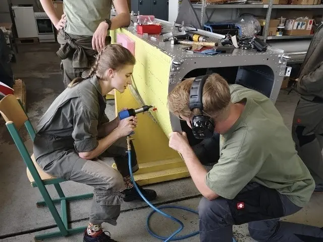 Schülerinnen und Schüler beim Warten eines Hubschraubers.