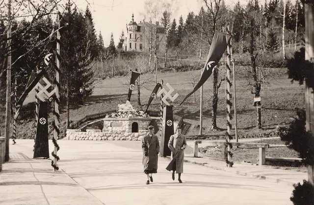 Die heutige 10.-Oktober-Straße (damals Schaubstraße) im Jahr 1938. Direkt nach dem „Anschluss“ Österreichs an das Deutsche Reich wurde Hermagor umgestaltet und mit den Insignien der faschistischen Machthaber besetzt. Die wenigen Menschen jüdischer Abstammung mussten fliehen, ihr Besitz wurde geraubt. Politisch Andersdenkende wurden im ganzen Tal verhaftet und deportiert. 1942 folgte die Deportation der Kärntner SlowenInnen aus dem Gailtal. Beim „Stadtspaziergang gegen das Vergessen“ werden Orte des Nationalsozialismus kritisch beleuchtet. 
