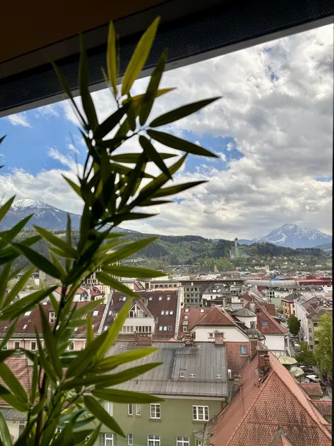Blick aus dem RAIQA über die Dächer Innsbrucks: Die Verbindung von urbanem Leben und alpiner Landschaft wird hier auf eindrucksvolle Weise erlebbar. | Foto: Lea Mantinger