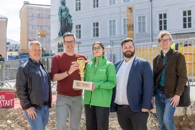 2025 war der Mozartplatz noch auf der Shortlist für den von Greenpeace verliehenen Betonschatz-Preis im Bundesland Salzburg. Der Goldene Presslufthammer dient als Appell, die Plätze zu entsiegeln. Die Stadt Salzburg kommt dem nun nach. (v.l.n.r.: Richard Friesacher – Straßen und Brückenamt, Bgm.-Stv. Kay-Michael Dankl, Melanie Ebner – Greenpeace, Felix Bauer – Amtsleiter Straßen- und Brückenamt sowie Maximilian Stechele – lohrer.hochrein landschaftsarchitekten und stadtplaner gmbh) | Foto: Stadt Salzburg/Wildbild/Doris Wild