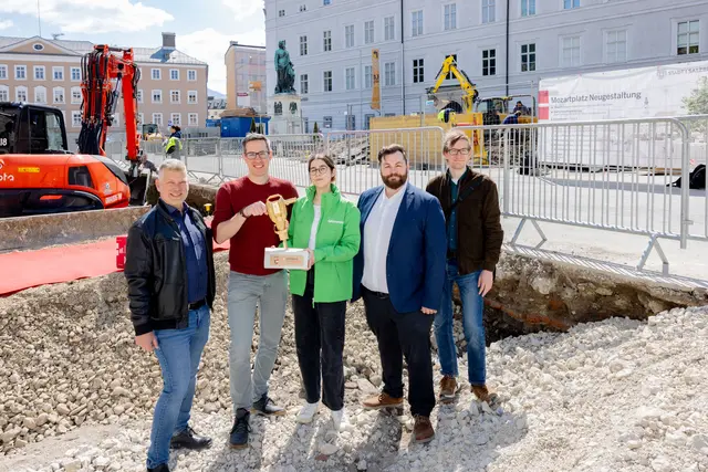 2025 war der Mozartplatz noch auf der Shortlist für den von Greenpeace verliehenen Betonschatz-Preis im Bundesland Salzburg. Der Goldene Presslufthammer dient als Appell, die Plätze zu entsiegeln. Die Stadt Salzburg kommt dem nun nach. (v.l.n.r.: Richard Friesacher – Straßen und Brückenamt, Bgm.-Stv. Kay-Michael Dankl, Melanie Ebner – Greenpeace, Felix Bauer – Amtsleiter Straßen- und Brückenamt sowie Maximilian Stechele – lohrer.hochrein landschaftsarchitekten und stadtplaner gmbh) | Foto: Stadt Salzburg/Wildbild/Doris Wild