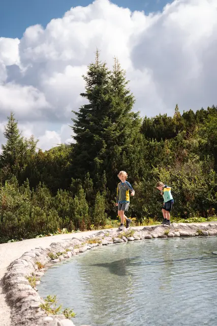 Abkühlung inmitten der Berge: Am Triassic Beach sorgen Kneipp‑ und Wasserspiele für erfrischende Momente und jede Menge Spaß. | Foto: Bergbahn Steinplatte