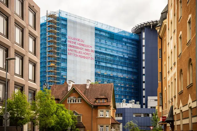 Der SOLANGE-Slogan auf der Klinik-Baustelle soll auf das Thema psychische Gesundheit bei Eltern aumerksam machen. | Foto: MUI/F. Lechner