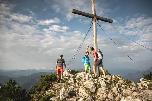 Gipfelerlebnis mit Weitblick: Am Gipfelkreuz genießen Besucher den Blick über das Drei‑Länder‑Eck. | Foto: Bergbahn Steinplatte