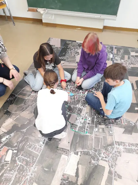 Volksschulkinder der VS Wölbling besprechen auf dem Luftbildteppiche ihre Schulwege  | Foto: NÖ Regional/Wulfrum