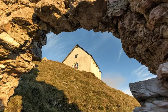 Zu sehen ist ein Gipfelhaus am Berg. 