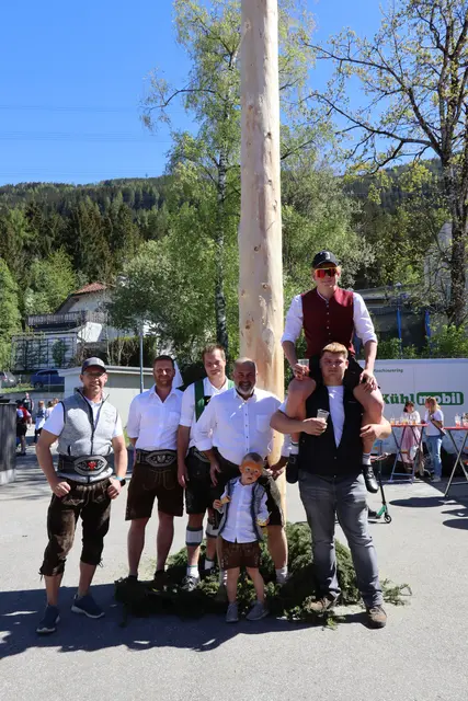 Der Rinner Maibaum ragt mit 26 Metern Höhe eindrucksvoll in den Himmel. Im Bild: Obmann des Brauchtumsvereins Thomas Flörl mit seinem Sohn Daniel sowie Florian Kiechl und weiteren Mitbietenden, die sich an der Maibaumversteigerung beteiligt haben. | Foto: Kendlbacher
