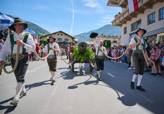 Die festlich geschmückte Kanone wurde von den starken Männern durch das Dorf gezogen.


