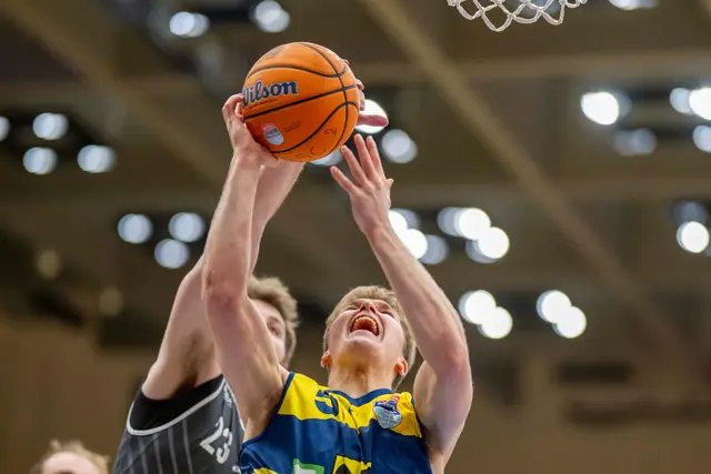 Zwei Basketballer kämpfen um den Ball. 