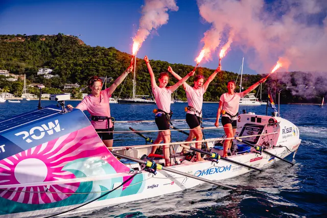 Vier Frauen mit Flairs auf einem Ruderboot. 