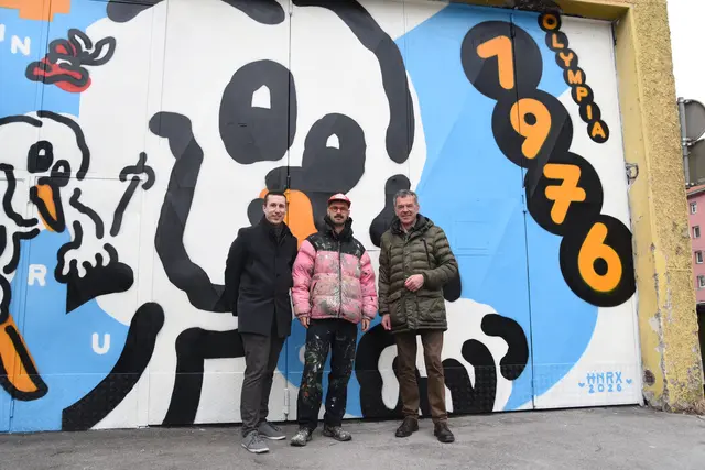 Ein Mural zur Erinnerung an die Spiele 1976. Der Künstler HNRX gemeinsam mit Vizebürgermeister Georg Willi (rechts) und dem Host des Olympia-Podcasts Tobias Rettenbacher (links) vor seinem Werk. | Foto: Stadt Innsbruck/I.Ullmann