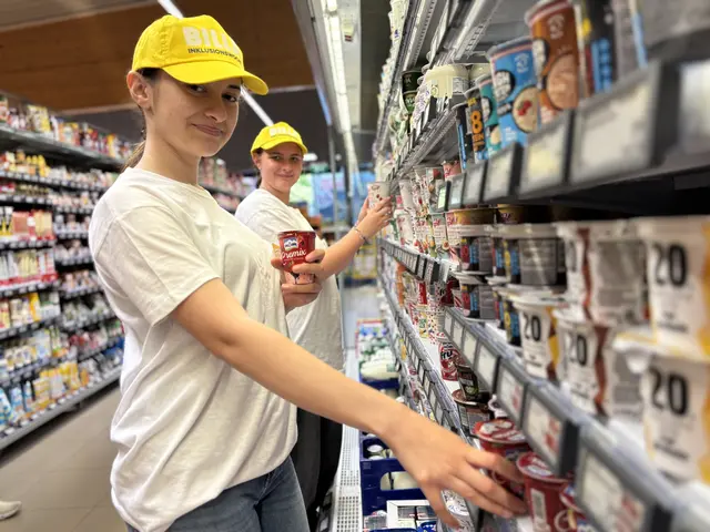 Zwei junge Frauen sortieren den Kühlbereich mit Milchprodukten.