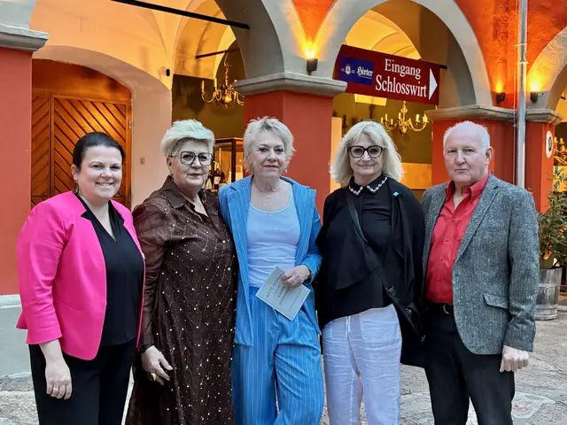 Fünf festlich gekleidete Personen stehen in einer Reihe und in die Kamera blickend.