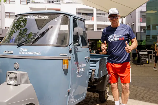 Ein entschlossener Gregor Bloéb, internationale Stimme des virtuellen Catcher Cars und in Telfs Fahrer des realen Zweitakt-Dreirades auf der Jagd nach dem letzten Läufer. | Foto: Uniqa/Höllwarth