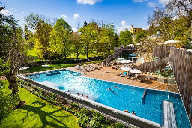 Das Thermalwasser im Außenbereich umgeben vom Kurpark ist zu sehen.