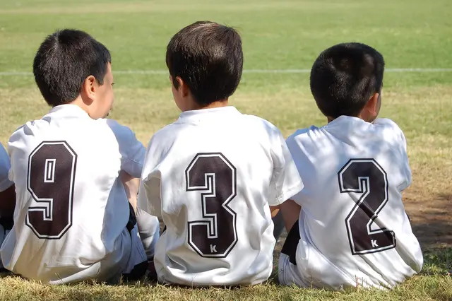 drei Kinder im Fussballtrikot