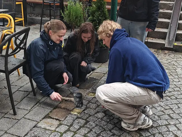 Schülerinnen reinigen einen Stolperstein nach der Verlegung in der Lofererstraße | Foto: Orte des Gedenkens