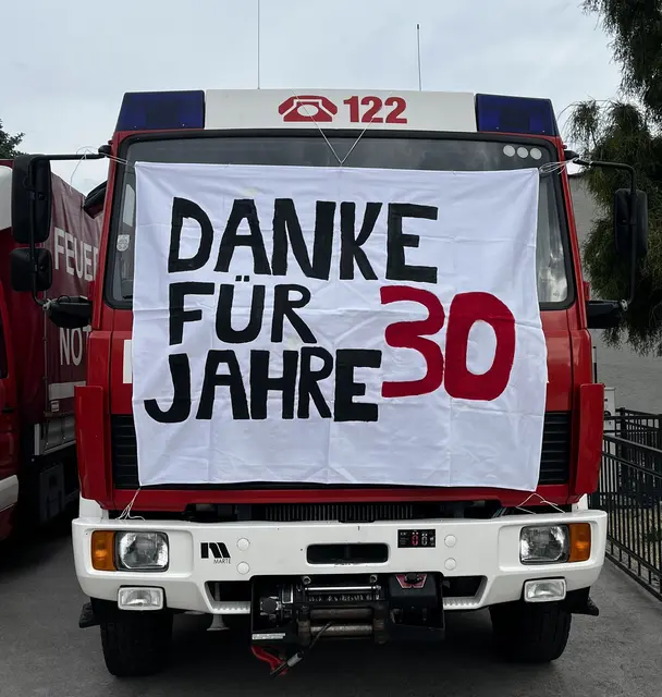 Feuerwehrauto mit Plakat: "Danke für 30 Jahre"