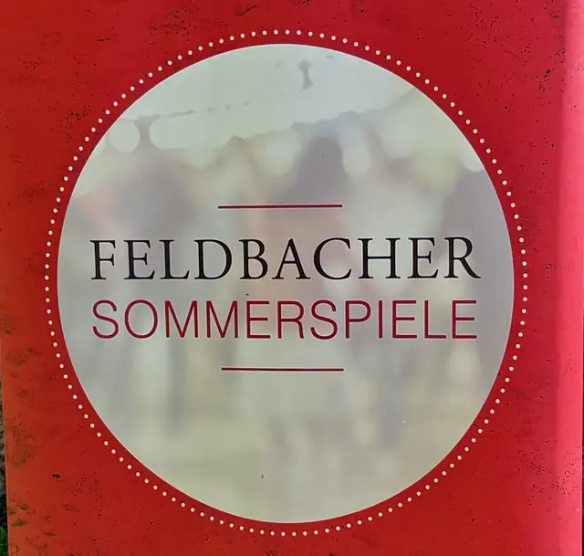 Ein kreisrundes Logo der Sommerspiele ist zu sehen.