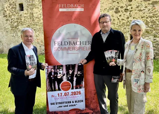 Drei Personen sind um ein Werbe-Rollup platziert und präsentieren das Kulturprogramm.