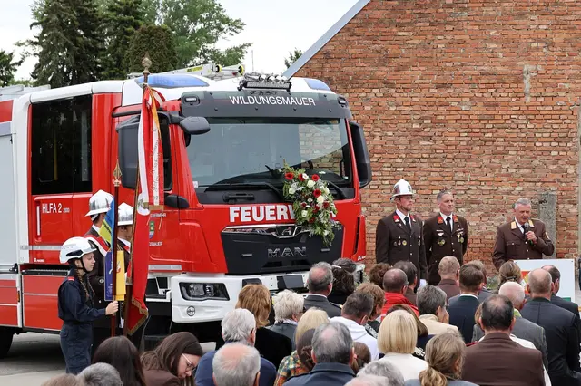 Blumengeschmücktes Feuerwehrauto mit Menschenmenge