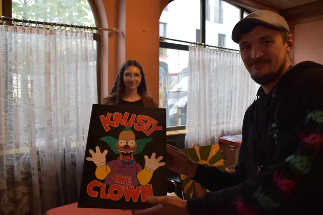 Lukas Größbacher (r.) erwirbt ein Bild der Künstlerin Selina Kraus.
