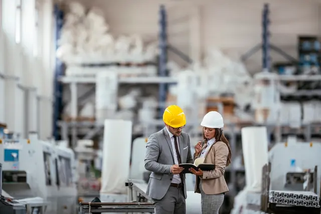 Unternehmerin und Unternehmer im Gespräch in einer Firma.