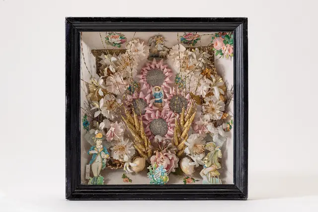 Arrangement aus Kunstblumen in einem Rahmen