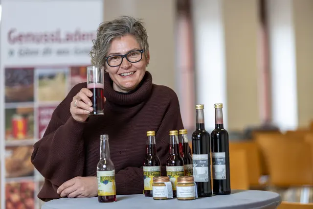 Sonja Trummer vom Milchmädchen Ziegenhof aus St. Anna/Aigen ist beim HochGenuss mit dabei. Sie hält ein Glas Holunderbeerensirup und damit eines ihrer Siegerprodukte in der Hand. 